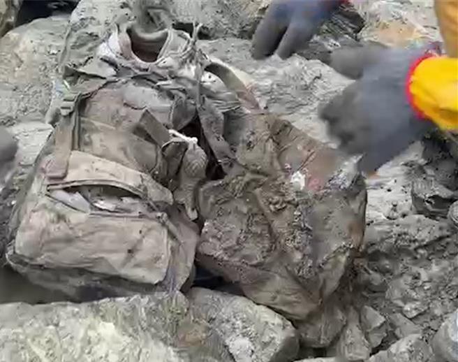 花莲强震迈入第8天，太鲁阁国家公园砂卡礑步道0.5K大崩壁为搜救热点，救难人员派遣怪手挺进后，今顺利带出4名罹难者，并在其中1具遗体旁发现一个挂有吊饰的后背包，与游妻出游当天背负的一样，并在遗体胸前斜背包找到4张健保卡，3张是游家小朋友所有，1张是游妻。（民眾提供／罗亦晽花莲传真）