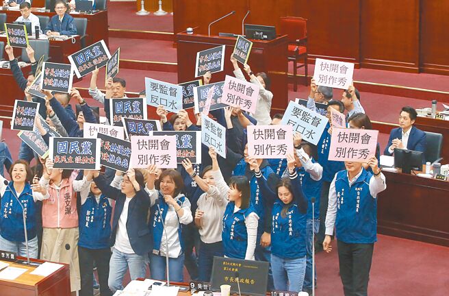 台北市長蔣萬安（後右）9日到台北市議會施政報告及備詢，民進黨議員發動杯葛，手舉「國民黨棄民主護幼主」牌子抗議，而國民黨議員則拿出「快開會別作秀」、「要監督反口水」牌子反制，場面一度混亂。（趙雙傑攝）