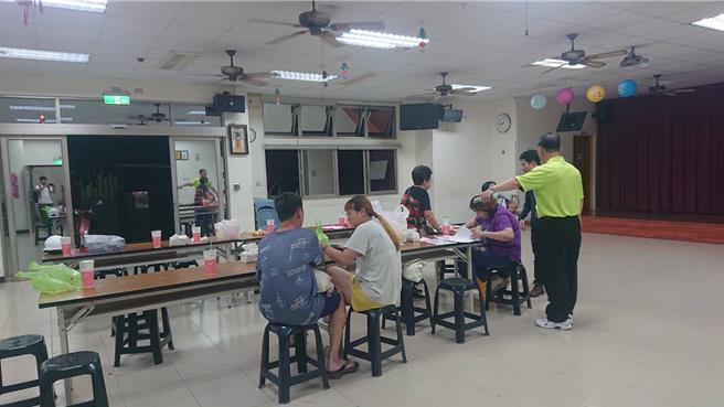 台南市北華街的住戶因隔壁空地的建案疑似掏空地基，連夜被撤離住家，先在社區活動中心討論安身之處。（程炳璋攝）