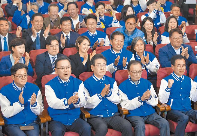 韩国国会选举10日投票，韩国最大在野党共同民主党党魁李在明（前排中），10日晚间与共同民主党领导层，一起庆祝出口民调结果大幅领先执政的国民力量党。（新华社）