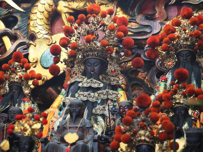 神蛾每年飞来向玄天上帝祝寿，已持续40年以上，今年则有7只神蛾停在玄天上帝衣冠上。（图片来源：嘉义县政府提供）