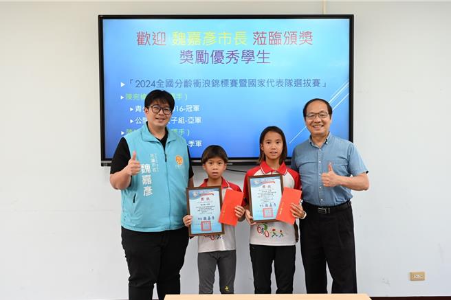 花莲市东华附小陈宛榆及陈柏榆姊弟，入选衝浪国手，市长魏嘉彦（左）、校长鲍明钧表扬姐弟优异运动成绩。（花莲市公所提供／王志伟花莲传真）