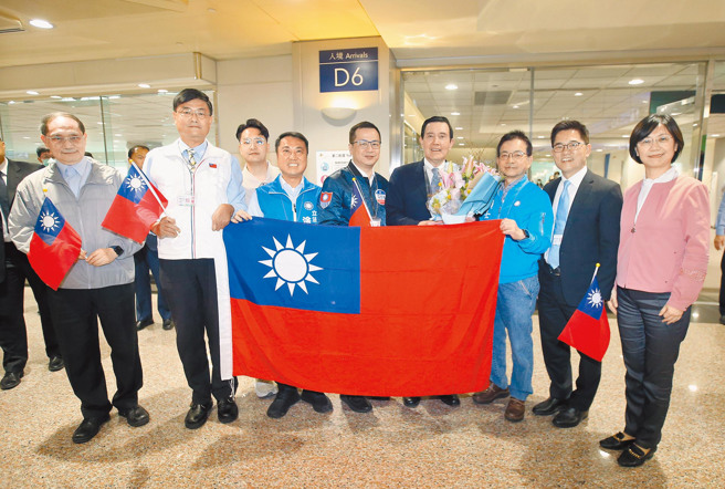 前总统马英九（右四）11日结束访问大陆行程搭机返台，立委翁晓玲（右起）、国民党秘书长黄健庭、立委赖士葆、立委罗智强（左五）及立委涂权吉（左四）等人带着国旗前往接机。（范扬光摄）