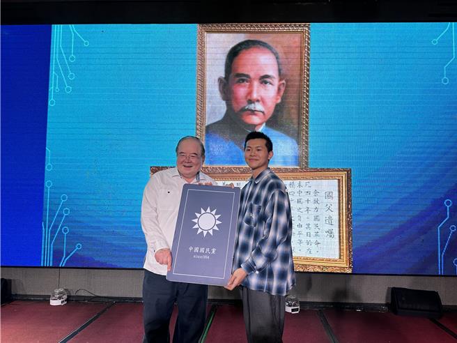 国民党新北市三重区党部12日办理主委交接，并为60位新党员举行入党仪式，由政大企管系三年级学生苏灿楷（右）代表向国民党前秘书长李乾龙（左）领取党证。（张铠乙摄）