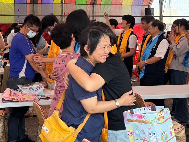 高三学生面临「转大人」之际，台中市潭子区108位学子13日于潭水亭观音庙进行成年礼仪式，家长为孩子「披巾」后温暖相拥。 （潘虹恩摄）