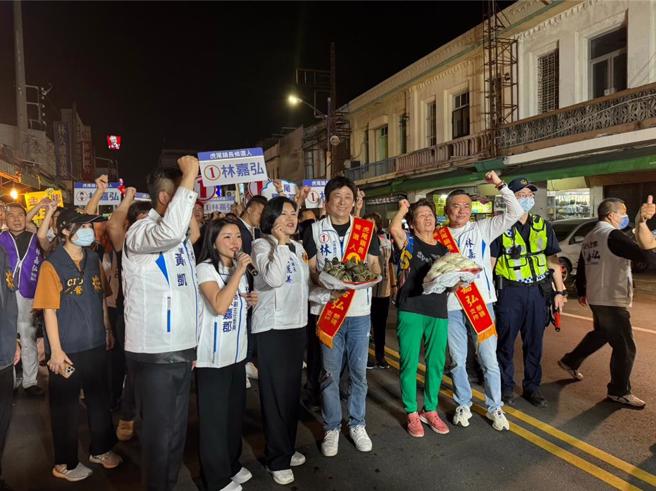 虎尾镇长补选候选人林嘉弘（前排右三）12日晚间徒步扫街，云林县长张丽善（左三）、立委张嘉郡（左二）、云林县议会议长黄凯（左一）、立委丁学忠（右一）、陪同，有热情的民眾送包子、粽子象徵「包中」，士气高昂。（周丽兰摄）