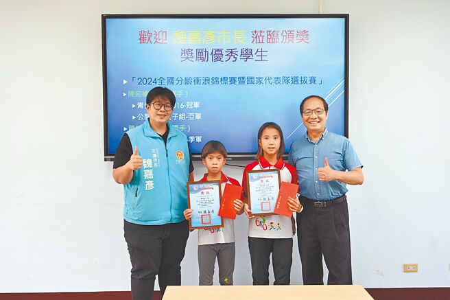 花蓮市東華附小陳宛榆（右二）及陳柏榆（左二）姊弟入選衝浪國手，校長鮑明鈞（右一）與市長魏嘉彥（左一）12日表揚姊弟。（花蓮市公所提供／王志偉花蓮傳真）