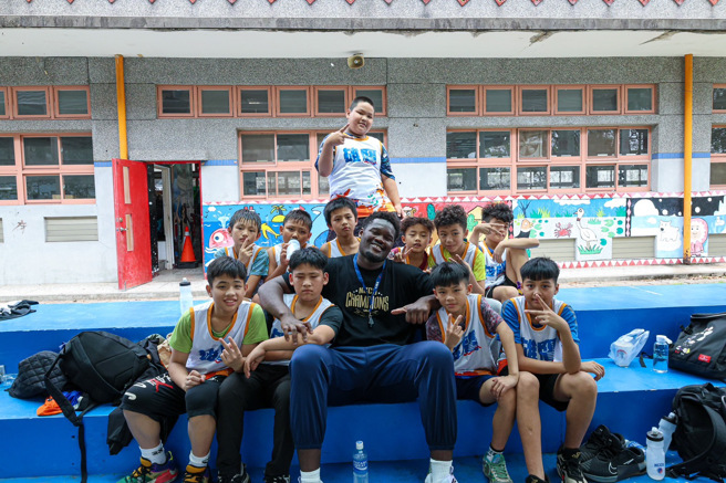 政大波波卡（前中）受到南澳國小學童歡迎。（政大雄鷹提供）