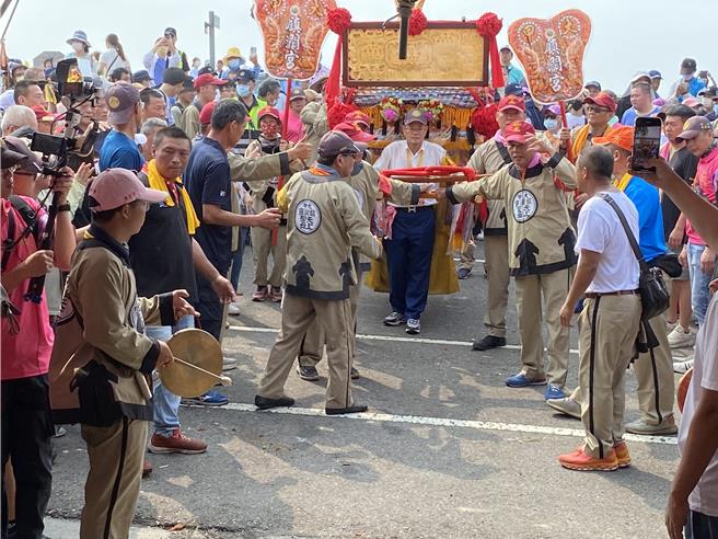 大甲鎮瀾宮媽祖14日完成9天8夜遶境進香行程，下午2時許鑾轎通過大甲溪橋，由鎮瀾宮董事李鴻文（中）接駕，廟方預估，當天湧入近30萬名信眾。（張妍溱攝）