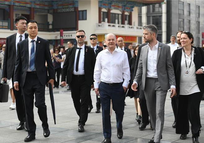 德国总理萧兹（正中间）一行14日在重庆解放碑、魁星楼广场等地漫步，感受当地风土人情。 （摘自中新社）