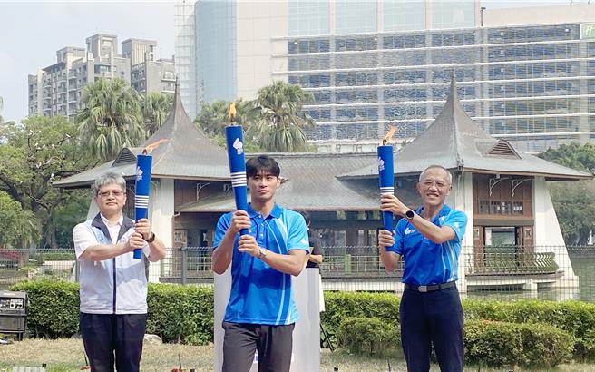 今年全大運由台灣體大承辦，15日在台中公園湖心亭前舉辦「聖火引燃」儀式，由台體大校長許光麃（右）、體育署副署長房瑞文（左）引燃聖火，與校友、東京奧運柔道國手楊勇緯（中）傳遞聖火交予傳遞手。（陳淑芬攝）