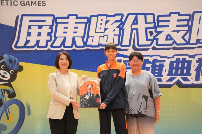 周春米(左)致赠黄宜婷(中)代表队服装。（图片来源：屏东县政府提供）