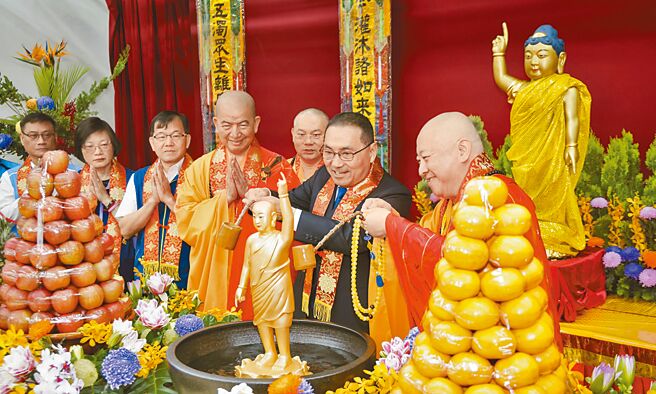 新北市長侯友宜（右二）14日參加新北市佛教會舉行的「浴佛節慶典大會」，手持浴佛勺舀香湯為佛陀沐浴，祈禱消弭災難。（新北市新聞局提供／張鎧乙新北傳真）