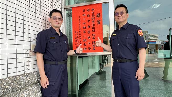 蚵寮派出所所长陈国益（左）从警29年，不忘初心坚持不懈，这次是第2次报考警大，终于成功录取，学甲警分局长廖水池（右）贴红榜祝贺。（张毓翎摄）