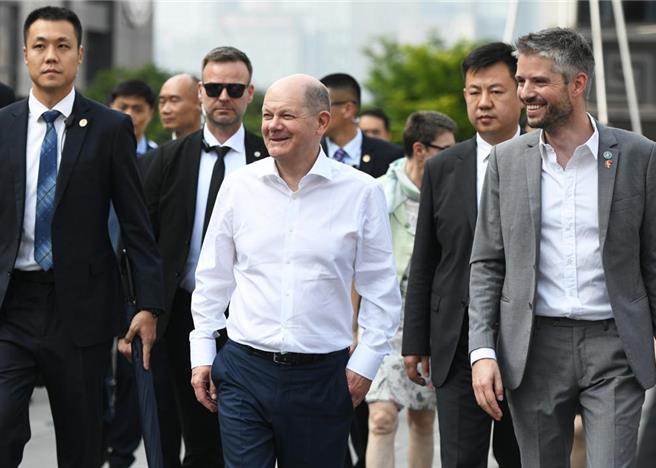 德国总理萧兹（正中间）一行14日在重庆解放碑、魁星楼广场等地漫步。（摘自中新社）