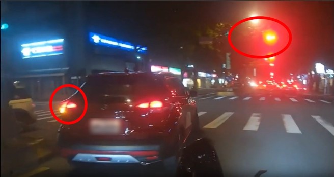 台北市一輛休旅車違規紅燈迴轉，沒想到警察就在後面，直接追上前開罰。（翻攝爆料公社）
