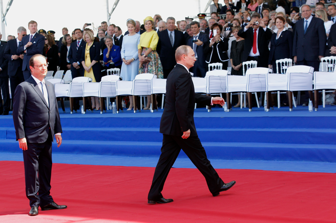 2014年6月6日，俄罗斯总统普丁（中）抵达法国西部参加诺曼第登陆70周年纪念活动，法国总统奥朗德（左）迎接。（美联社）