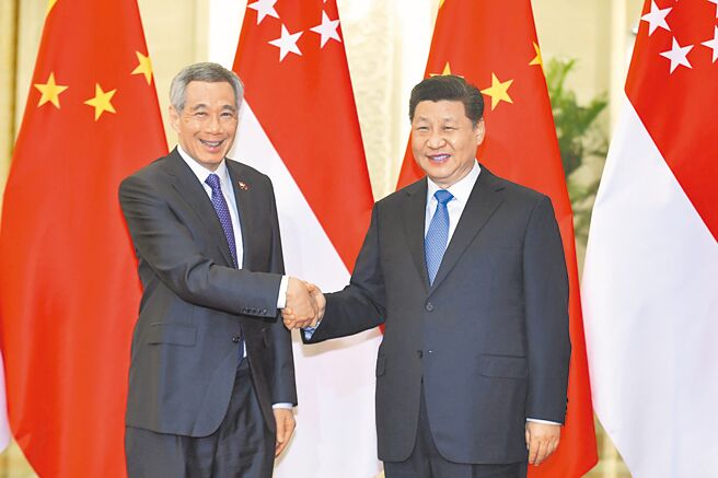新加坡对两岸事务的基本立场是希望维持台海现状，争议能搁置就先搁置。图为中国国家主席习近平（右）于2019年在北京人民大会堂会见李显龙（左）。（路透）