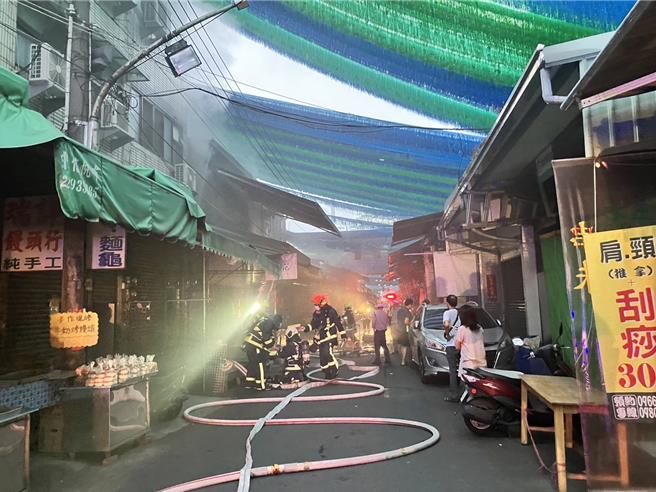 台中市南区第三市场内1栋建筑，17日清晨突然起火燃烧，消防局派遣10辆消防车到场，利用电锯锯开铁门灌救，顺利扑灭火势，幸无人伤亡。（民眾提供／王煌忠台中传真）