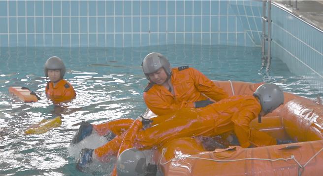 國防部17日在岡山國軍空勤人員求生訓練中心舉行模擬水中事故演練，圖為人員離開沒入水面的艙體後登上救生筏。（林瑞益攝）