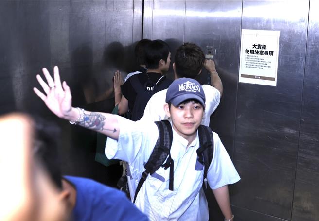 Lulu在电梯角落，面对提问不发一语。（陈俊吉摄）