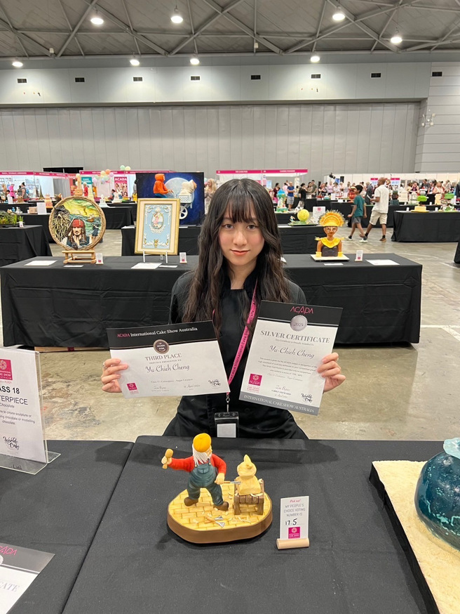 餐旅系三年級學生鄭伃倢，在糖霜餅乾組作品「奇幻之旅」得到金牌及無界限糖工藝組作品「夢想雕刻家」得到銀牌。他以「夢想雕刻家」作品中爺爺的形象，表達了對藝術和家人的深厚情感。(照片/醒吾科大提供)