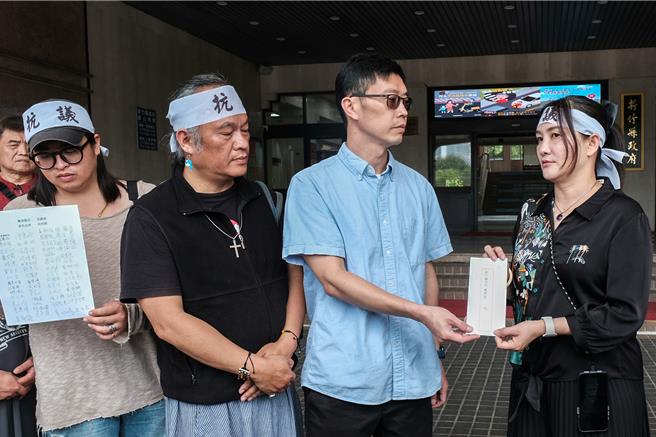 尖石鄉民宿業者羅麗娟（右）抗議尖石鄉公所垃圾「隨袋徵收」處理費價高，遞交陳情書給環保局長蕭宏杰（右二）要求主持公道。（羅浚濱攝）