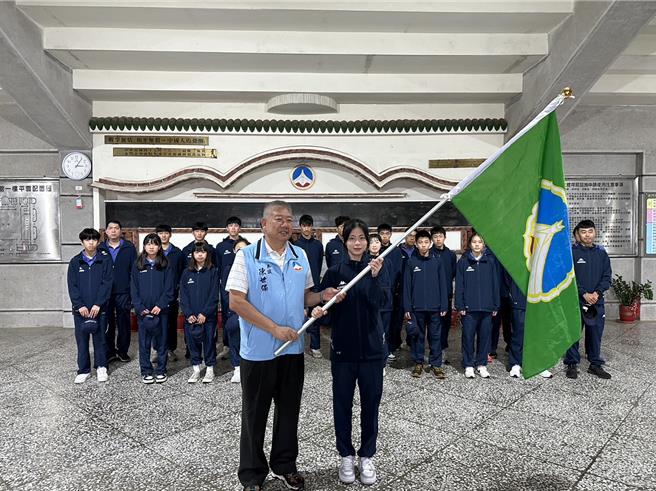 2024全中運將於4月20至25日在台北市盛大登場，縣府參議陳世保(左)今代表授旗給金門縣代表隊選手金門高中林玟(右)。(圖／金門縣教育處提供)