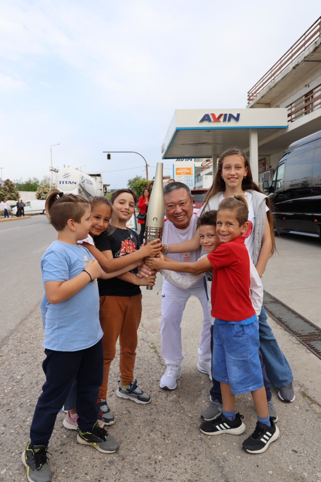 中華奧會主席林鴻道（中）參與巴黎奧運聖火傳遞，和當地孩童開心合照。（中華奧會提供）