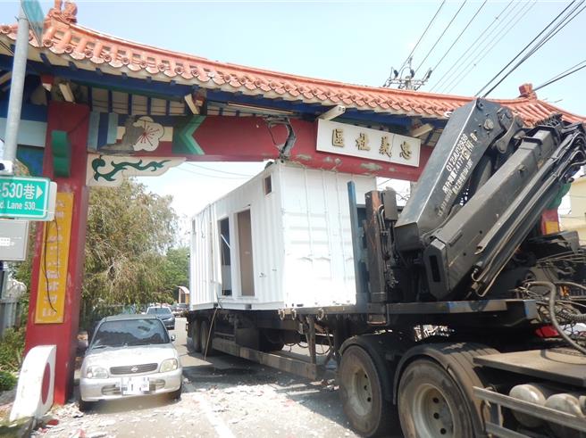 1辆大货车17日行经台中市大雅区月祥路，后车斗货箱擦撞道路上方忠义社区牌楼，当场牌楼受损、满地瓦砾，并波及一旁3辆自小客车，目前暂时封闭道路，施工人员将牌楼拆除。（大雅警分局提供／张妍溱台中传真）