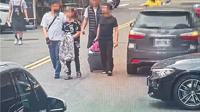 陈姓男子（左二）疑因偷钱，被酒店员工当街「上铐逮捕」，手铐上盖着外套，走在大街上，犹如刑警办案解送人犯，引起路人侧目。（翻摄画面）