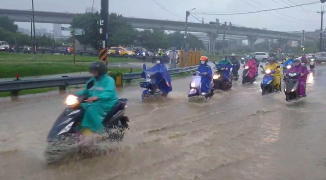 新北市消防局今一早发布降雨情形，其中新庄降雨量突破78毫米，五股芦洲淹成小河，骑士涉水而过。（图 / 刘咏韵翻摄）
