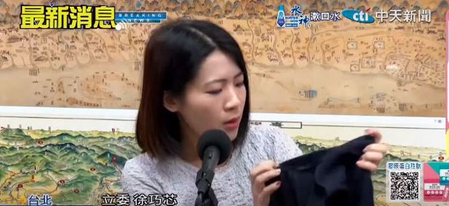  徐巧芯脱外套。（取自中天新闻）