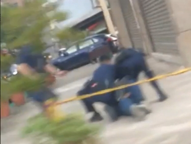 藍衣男子持刀與警方僵持，支援警力到達，從後方偷偷靠近，成功奪刀將男子壓制。（翻攝爆料公社）