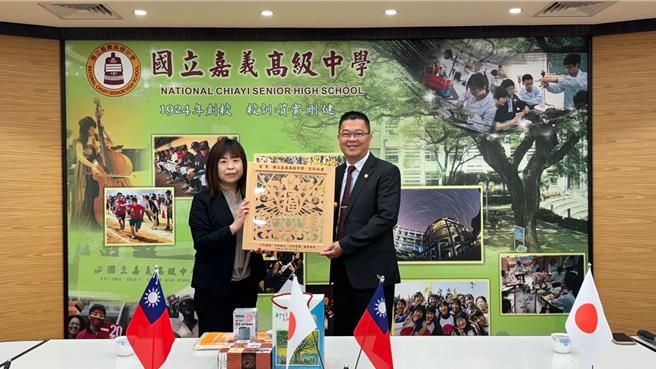 嘉中校長陳元泰代表接受日本南三陸町送的衫木雕畫賀禮。（嘉中提供／廖素慧嘉市傳真）