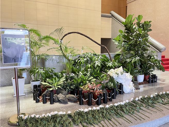 最高法院19日在一樓大庭設追悼區，並在盆栽上繫上白絲帶，法官們陸續獻花表達思念。（林偉信攝）