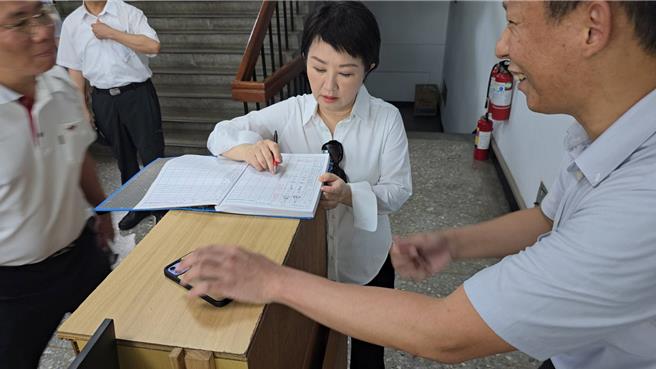 台中市长卢秀燕（中）19日上午亲自到清水警分局慰问第一线员警，并在勤务出入登记簿签名，上面写「慰勤，同仁辛苦了！」。（清水警分局提供／张妍溱台中传真）