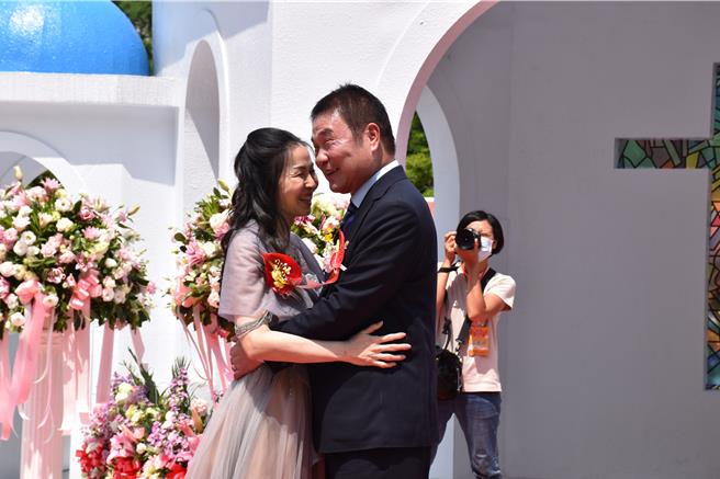 「2024苗栗客家桐花婚禮」20日在三義鄉西湖渡假村浪漫登場，苗栗縣長鍾東錦及夫人陳美琦展現最深愛意。（謝明俊攝）
