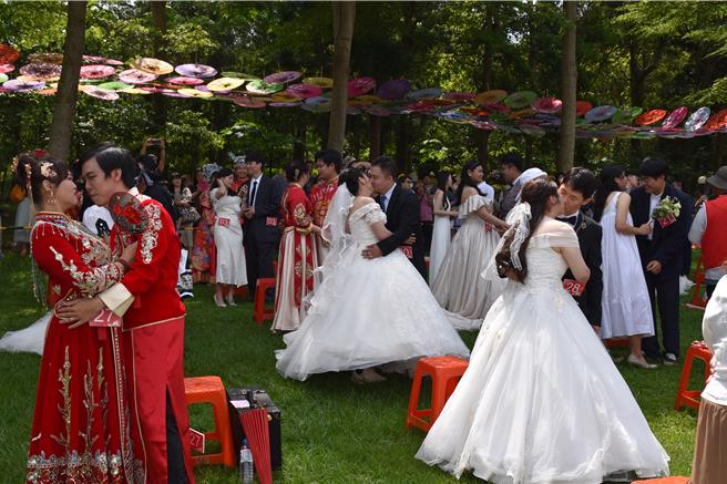 「2024苗栗客家桐花婚禮」20日在三義鄉西湖渡假村浪漫登場，36對新人以吻示愛。（謝明俊攝）