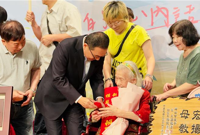 侯友宜亲自将获奖者的纪念品送到模范母亲手上。（吕健豪摄）