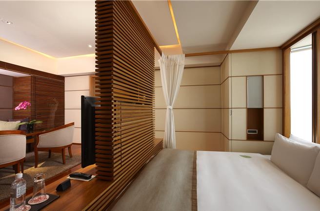 「极致宠爱妈咪假期」住房专案，可入住最高楼层的沐兰套房，该套房有倚着落地窗的大床，引入窗外阳光与绿意，木质的地板与隔栅充满南国风情。(台北晶华酒店提供)