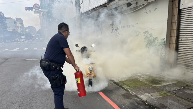民眾的微型电动二轮车突然冒烟，莺歌警拿灭火器协助灭火。（翻摄画面）