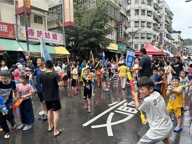 今年浴佛节活动热闹非凡，小朋友们拿着水枪互喷，即使全身湿透，仍玩得不亦乐乎。（高钧麟摄）