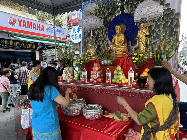 民眾排队净水浴佛，双手合十礼佛参拜，替自己及亲友祈福。（高钧麟摄）