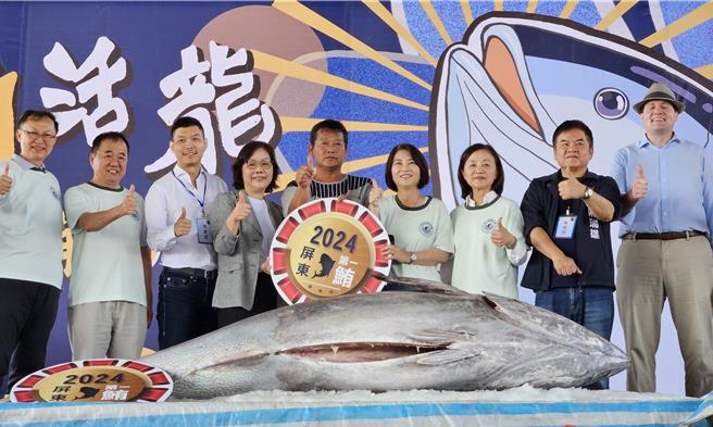 今年屏東第一鮪由莊光陽（中）捕獲，澎坊免稅商店總經理常春媚（左四）以每公斤1萬3百元得標。（羅琦文攝）
