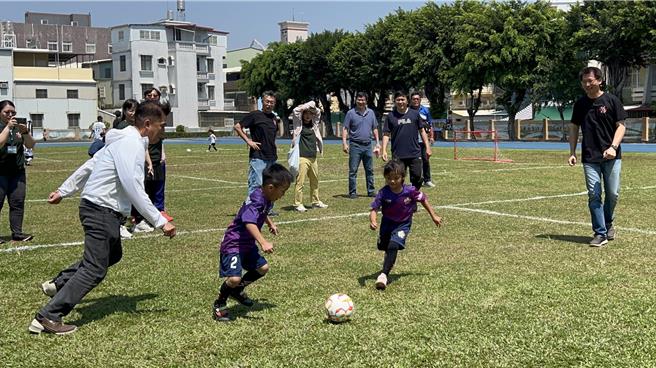 「JUNGLE JUMP宝宝丛林探险」21日在屏东市忠孝国小举行，副县长黄国荣（右一）与县议员李世斌（左一）一起上场与小朋友踢足球同乐。（罗琦文摄）