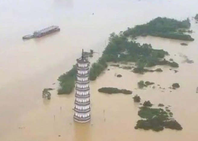 广东韶关市暴雨成灾导致当地江湾镇大量民房遭洪水淹没，只余境内文峰塔的独自立于水中。（图／东网）