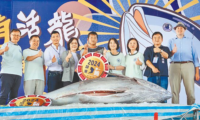 今年屏东第1鲔由庄光阳（中）捕获，澎坊免税商店总经理常春媚（左四）以每公斤1万300元得标。（罗琦文摄）