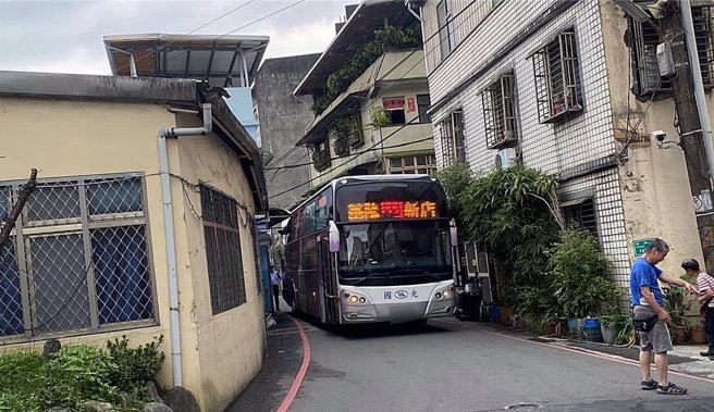 基隆市龙安街路辐狭窄，23日上午却发生客运误闯，客运侧面的车窗撞上路边店家的雨遮受损，最终只能倒车脱困。（翻摄照片／张志康基隆传真）