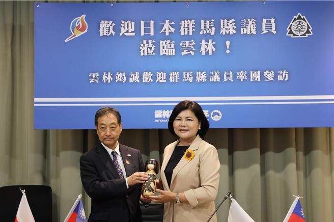 日群马县资深议员星野宽野寛赠送群马县有名的工艺品木芥子娃娃给张丽善。（周丽兰摄）